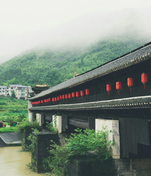 a house with red lanterns that are over looking a field