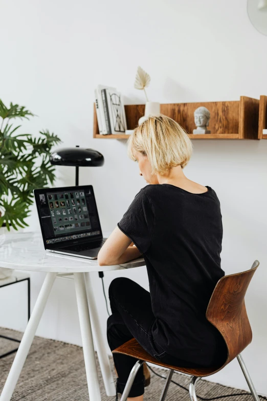 woman sitting at a table with a laptop computer