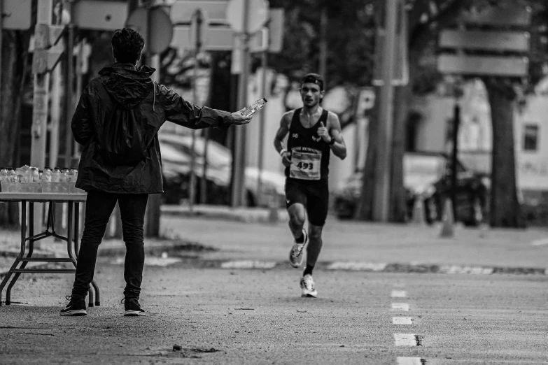 a man and another man running on the street in the rain