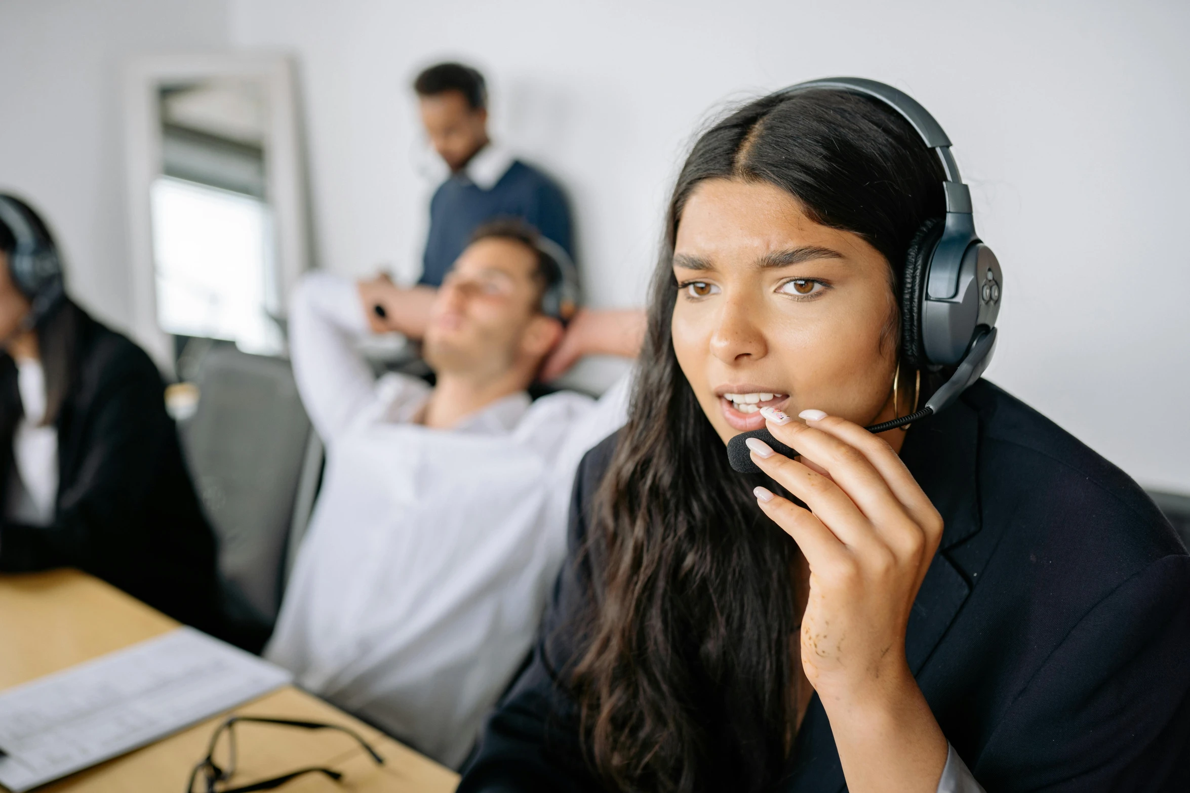 a woman sitting in front of two men in headphones