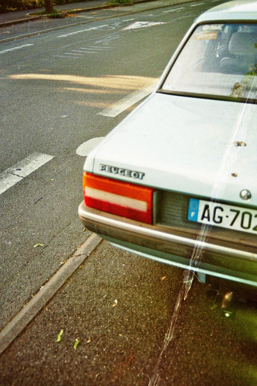 a white car parked in front of a street with no traffic