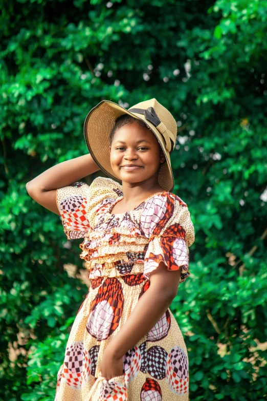 a girl in dress and hat holding onto a small stick