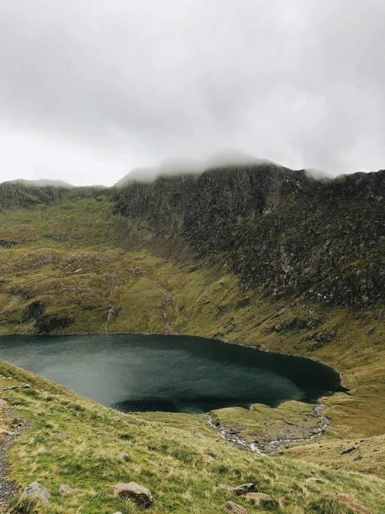 a large, placid lake sits in front of a mountain range