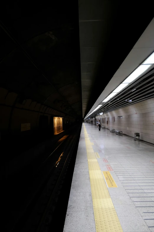 people waiting for a train at an empty subway station