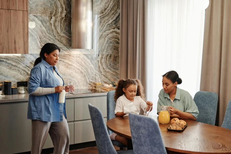 woman with two small girls sitting at a table eating