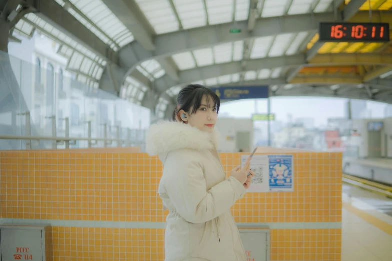 a woman is standing in a subway station