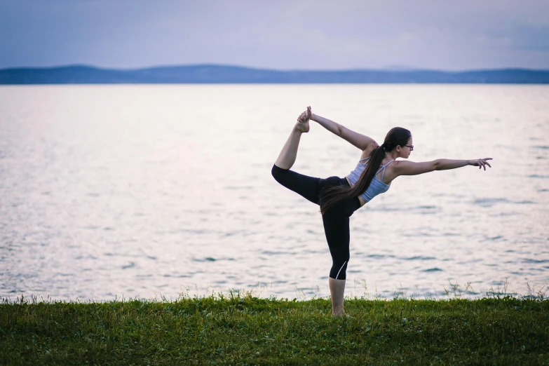 a person in yoga poses near water