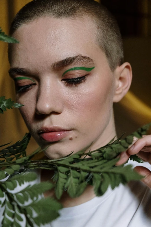 a young woman holding a green plant with green leaves