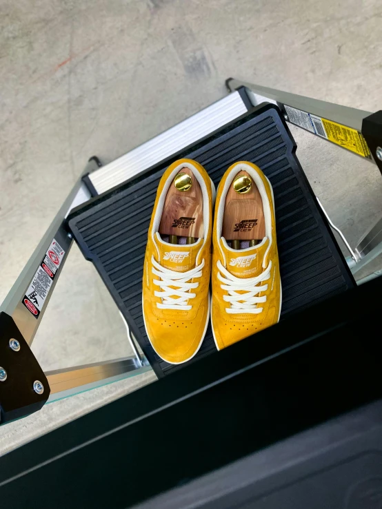 yellow tennis shoes hanging on the handle of an escalator