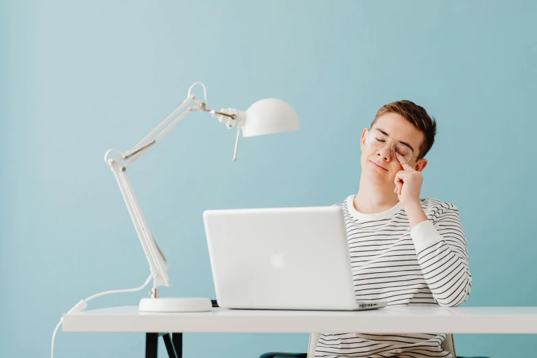 young woman with glasses working on a laptop