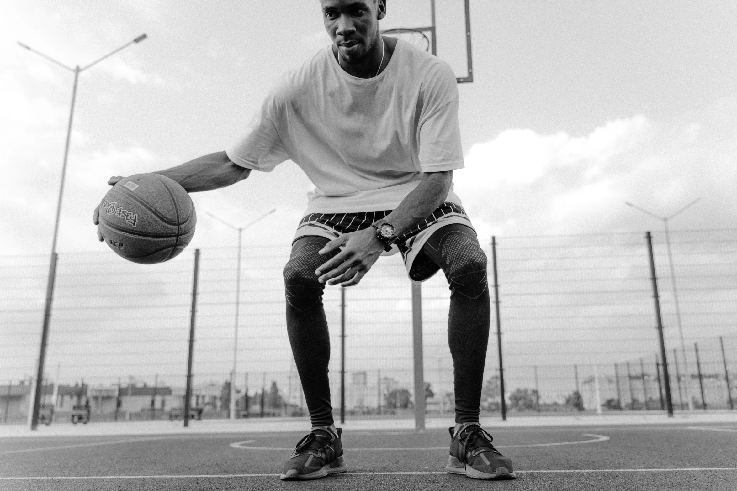 a basketball player crouching down while holding a ball