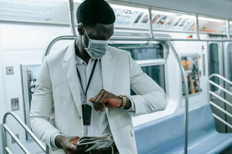 a man wearing a face mask walking on a subway