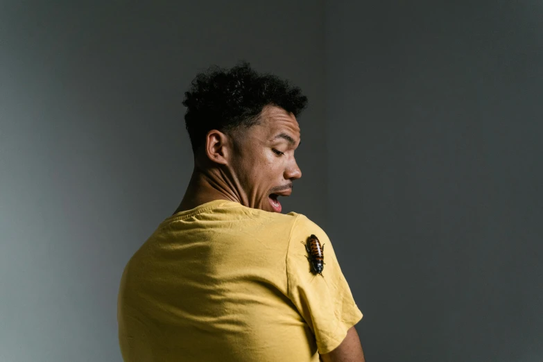 a man in a yellow t - shirt holding a piece of metal