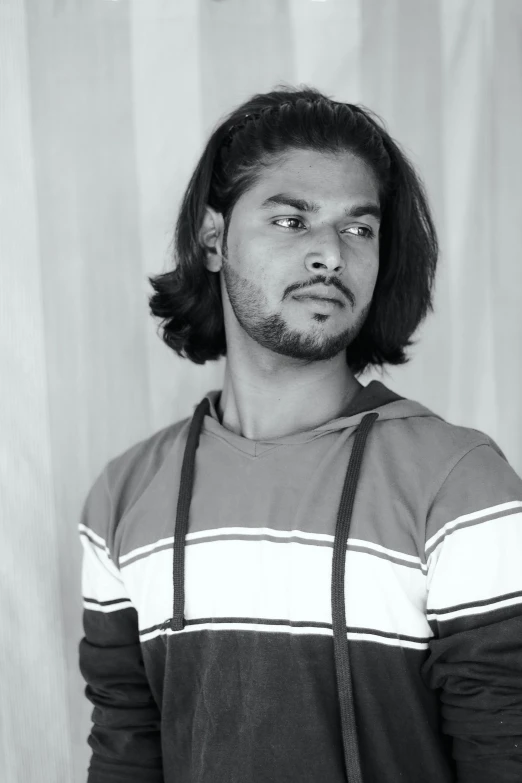 an indian man wearing suspenders looking at the camera