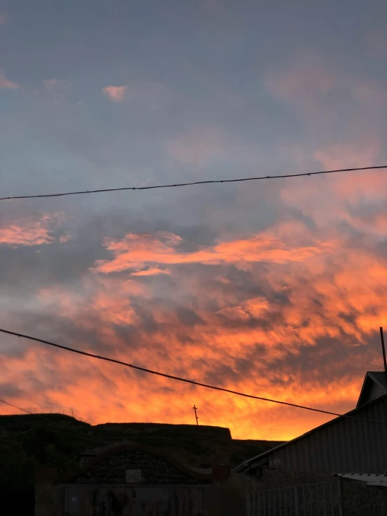 a long cable hanging from a wire with the sunset behind