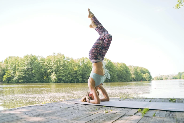 a woman doing yoga poses on the water