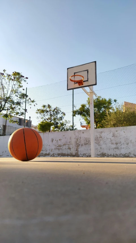 a basketball in the ground in front of an urban fence