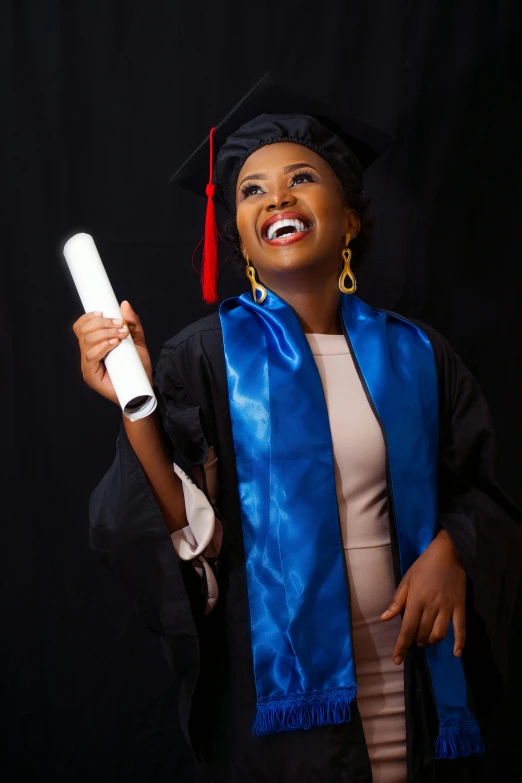 a graduate posing for a po while holding a diploma