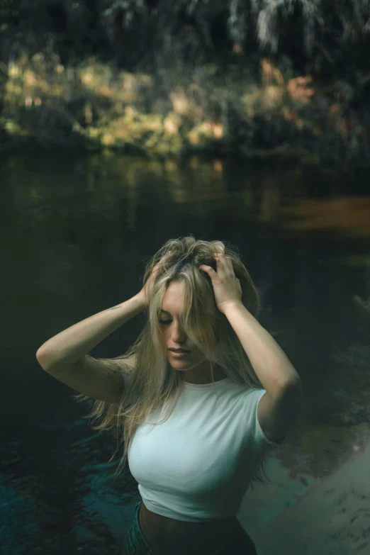 a woman in a white shirt posing near water