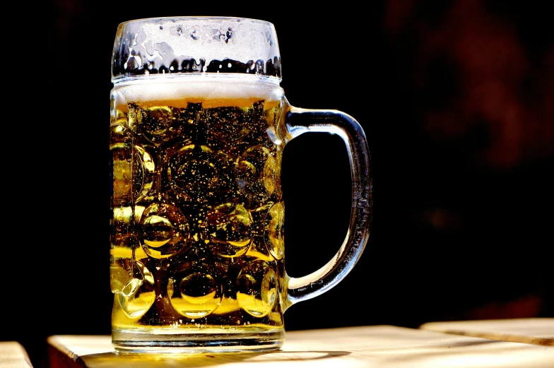 a glass mug filled with beer sitting on a table