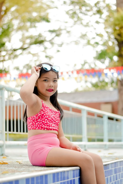 a young asian woman sitting on a ledge