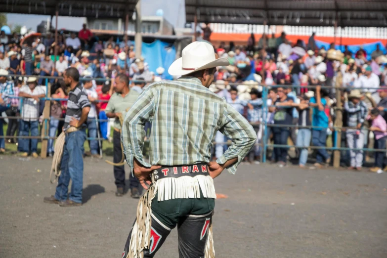 a cowboy is standing in front of a crowd