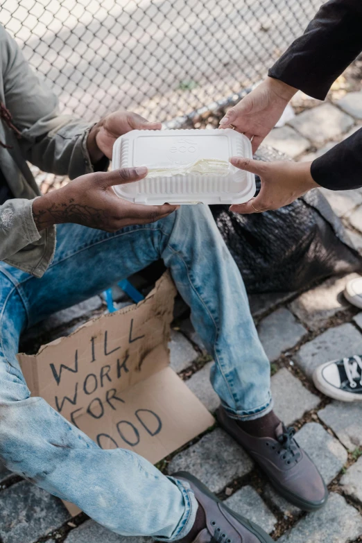 two men sitting on the ground holding a plate