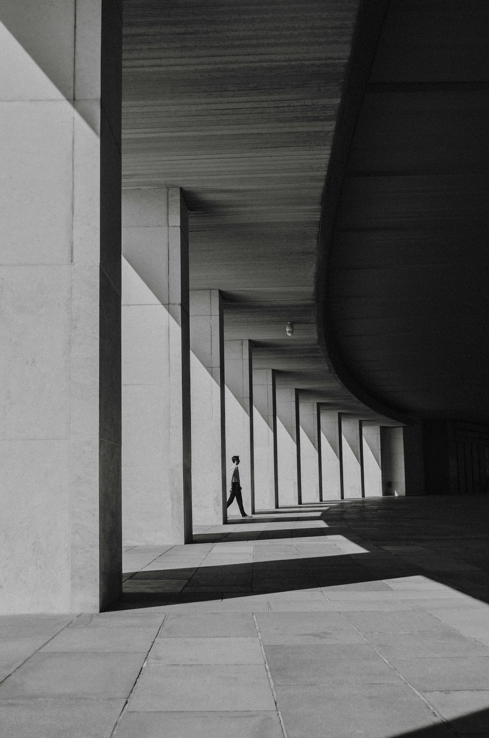 the back of a long building with a man walking down the middle of it