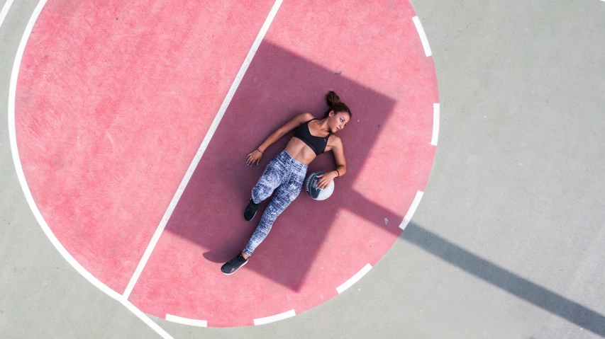 a woman sits on the pink side walk and takes in the beautiful view