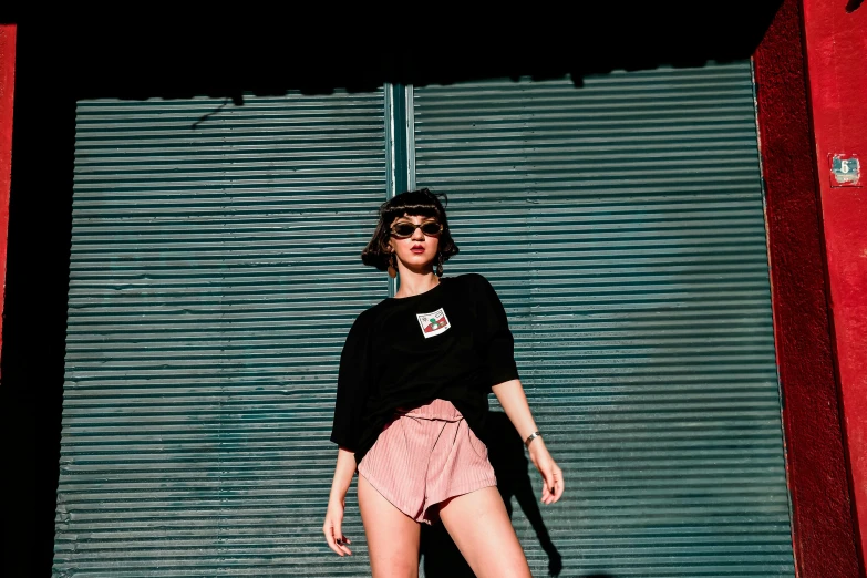 a woman standing on a skateboard in front of shutters