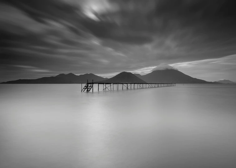 black and white pograph of water with dock