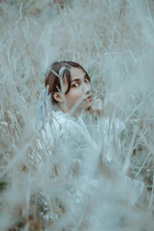 a woman with dark hair and a white dress in a field