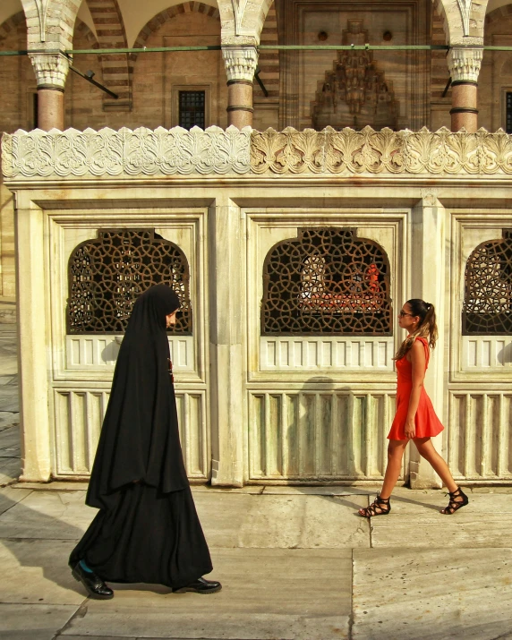 a young woman walking along side of a building