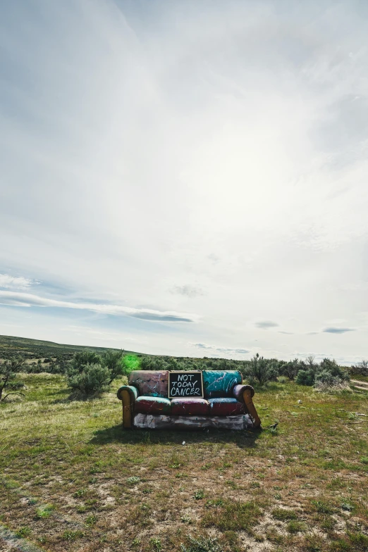 there is a couch in the middle of the field