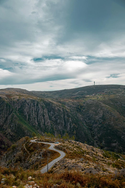 a view from the top of a mountain, with a winding road leading to the sky