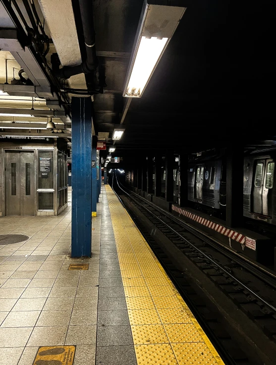 there is a yellow and blue train at a station