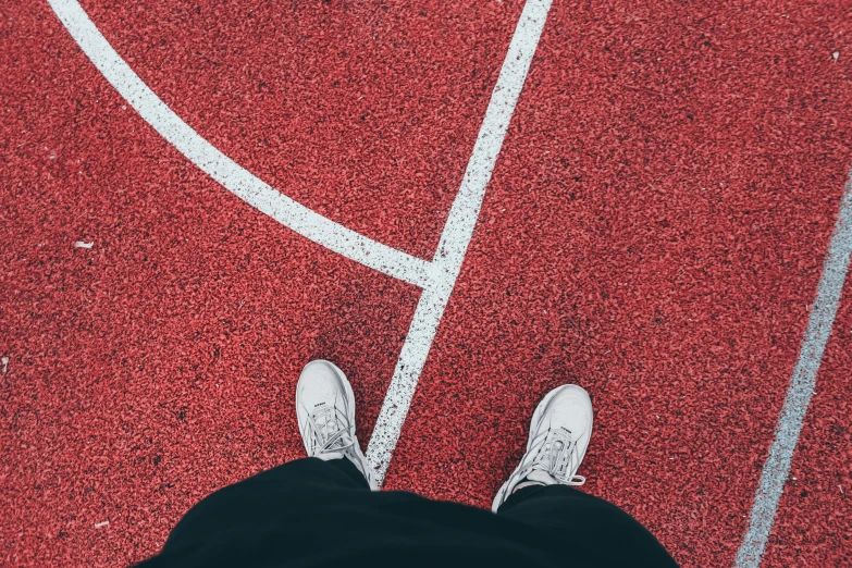 someone is standing on the tennis court while wearing sneakers