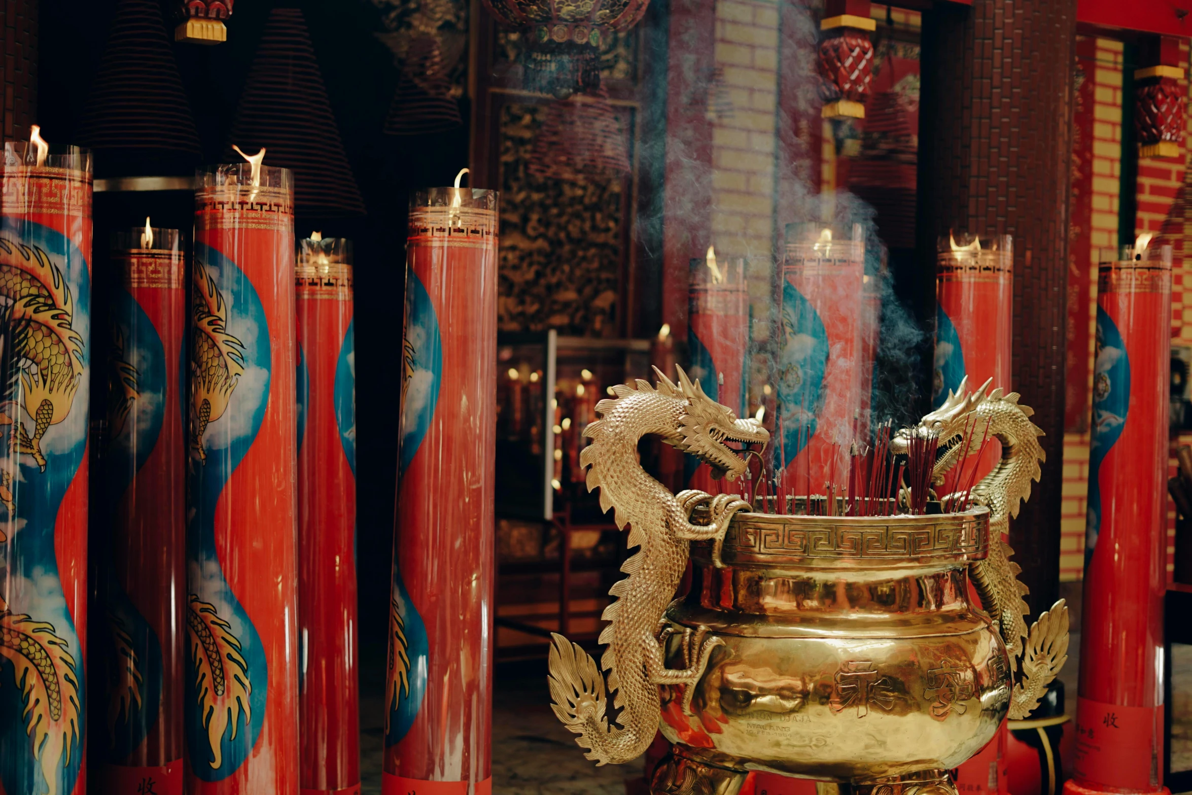 a dragon statue is displayed near some red candles