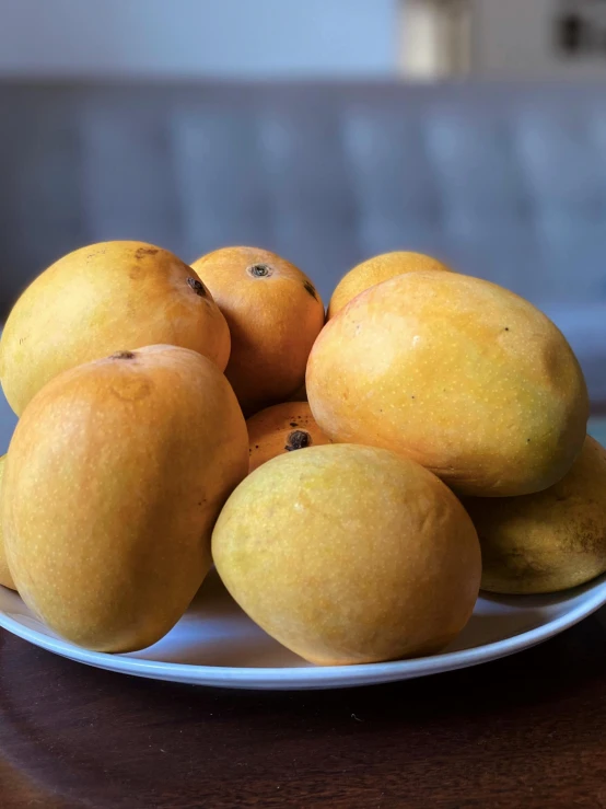 a plate full of oranges on top of a wooden table