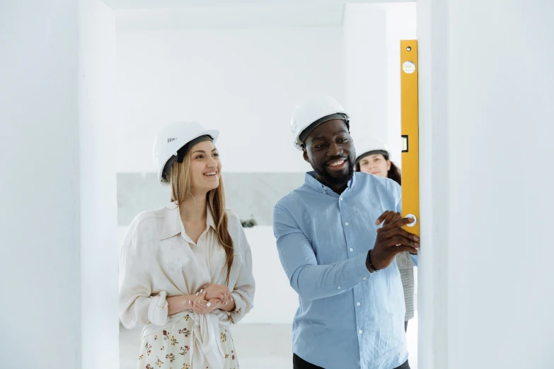 two people with construction helmets standing in a white room