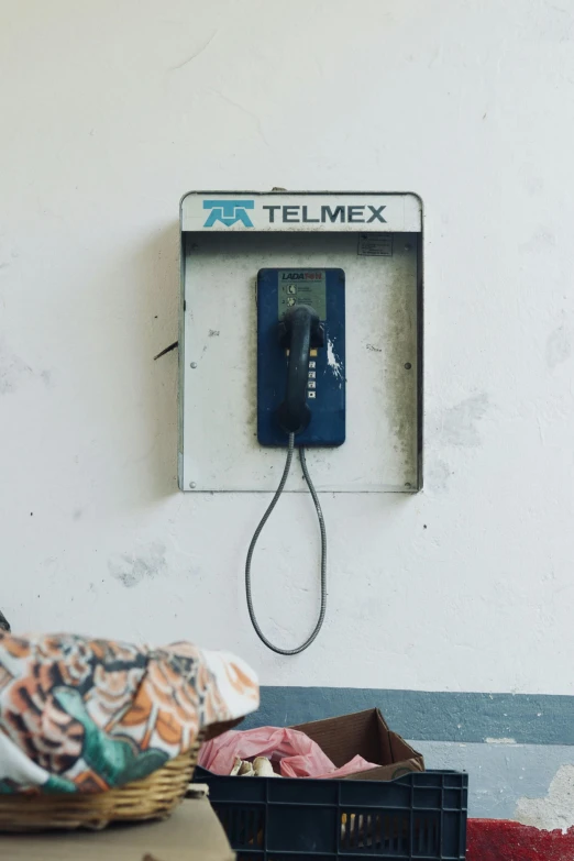 an old phone hooked up to a wall in a room
