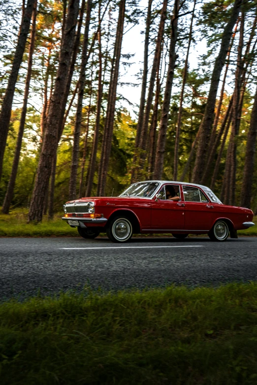 a classic sports car is driving down the road