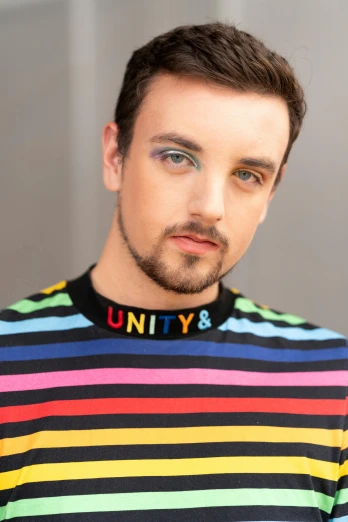 man wearing a multi colored shirt looking at the camera