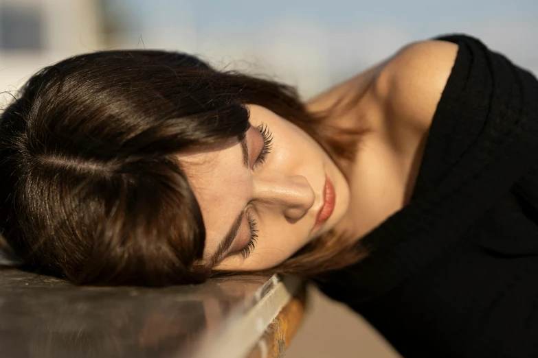 a woman laying down with her eyes closed