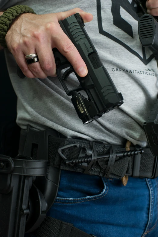 an officer is holding a black gun and wearing a green hat