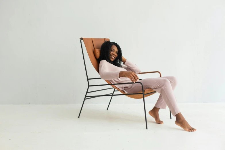 a woman in a pink sweater is sitting on a chair