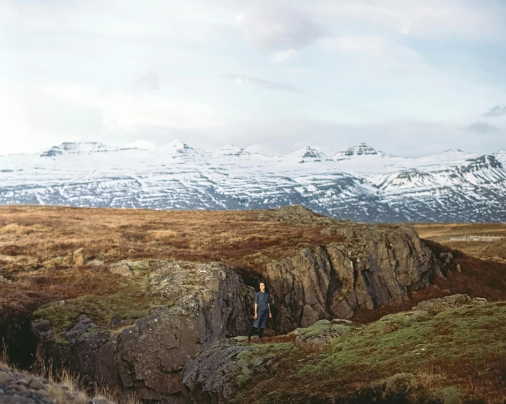 a man stands in a  between two mountains