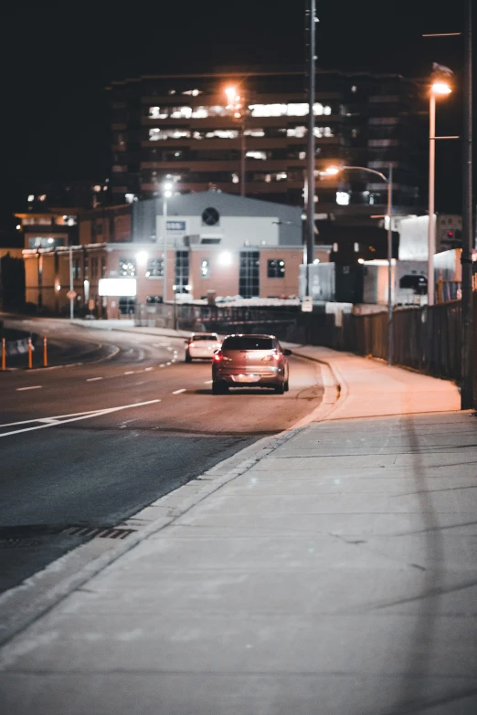 a red sports car on a city road at night