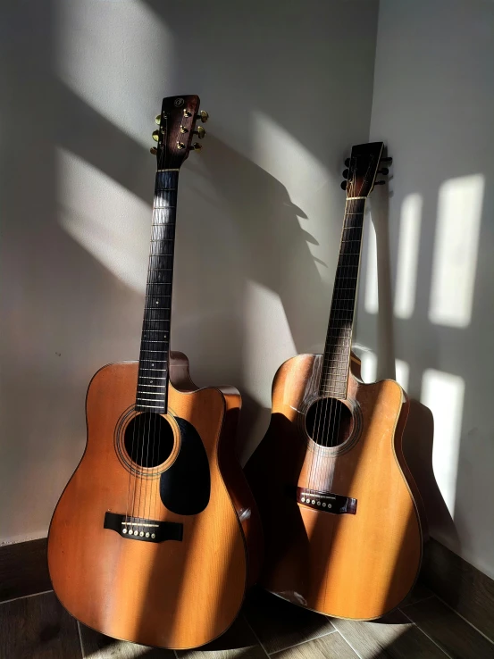 two guitars, one is orange with a dark frit