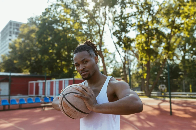 a man holding a basketball ball on top of a basketball court